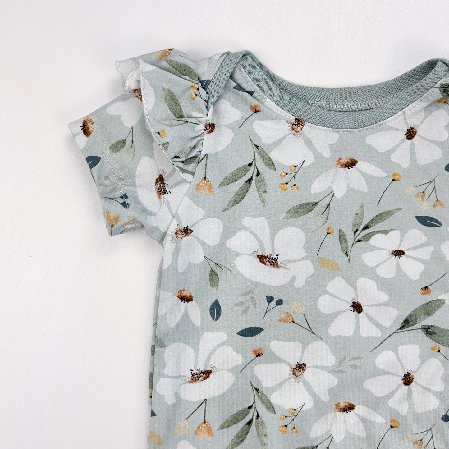 Blütenliebe – Babybody mit zartem Blumenprint & Rüschendetails